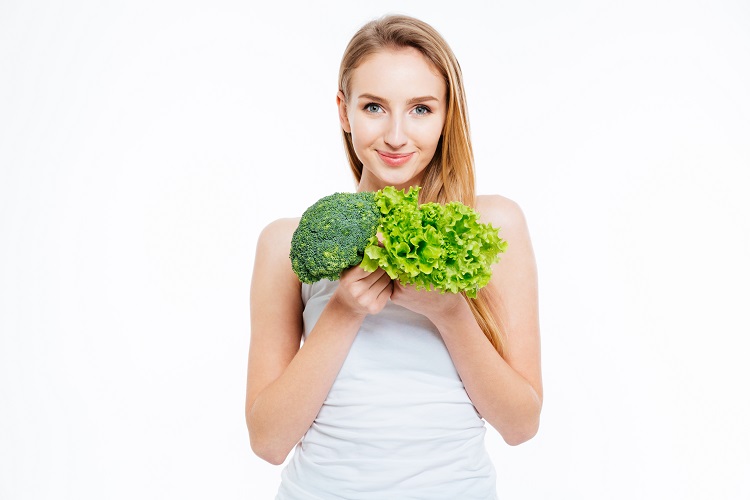 Woman holding cauliflower and green salad