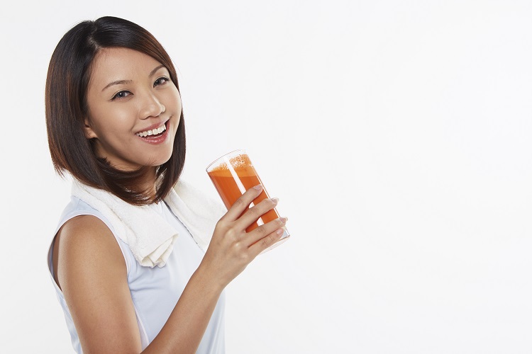 Woman holding a glass of carrot juice