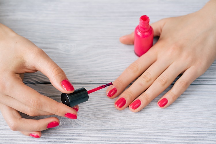 Female hands painted nails with red lacquer